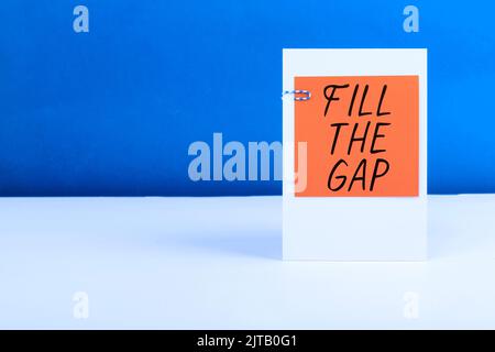 Inspiration mit Schild „Fill the Gap“. Wort geschrieben auf legte er fehlende Teil an seinem richtigen Ort Lösung für das Puzzle Frau mit Tablet präsentieren Stockfoto