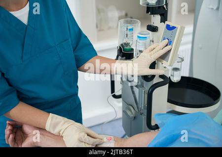 Ein Arzt tropft auf einen Patienten in einem medizinischen Zentrum Stockfoto