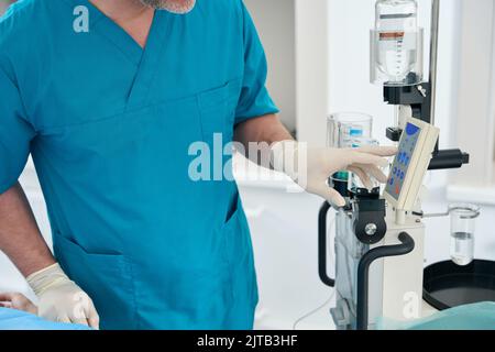 Der Diagnostiker arbeitet mit dem Kontrastkontrollinjektor im modernen Diagnosestraum Stockfoto