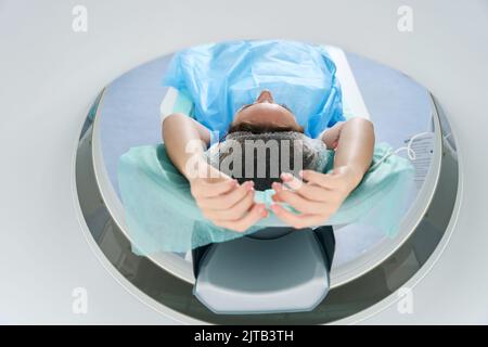 Der Patient wird für die Computertomographie in die Tomographiekammer gestellt Stockfoto