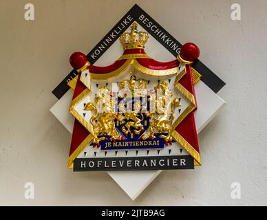 Eine Wappentafel mit dem niederländischen Königswappen und dem Wort „Hofleverancier“ hängt an der Fassade des Hotels und Restaurants Carelshaven in Delden, Gemeinde Hof van Twente, Niederlande. Das 1772 gegründete Haus trug von 1972 bis 1986 einen Michelin-Stern und führt den königlichen Titel „Hofleverancier“ (Inhaber einer Royal Warrant). Der Titel wird an niederländische Unternehmen verliehen, die seit mindestens 100 Jahren existieren und königliche Kunden beliefern. Stockfoto