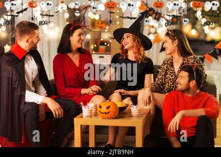 Fröhliche Freunde in halloween Kostümen auf der Heimparty Stockfoto