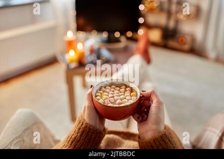 Frau schaut an halloween Fernsehen und trinkt Kakao Stockfoto