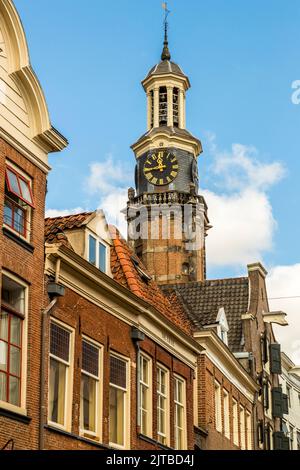 Der Wijnhuistoren, der Wahrzeichenturm von Zutphen, einer von neun historischen Hansestädten an der IJssel, Provinz Gelderland, Niederlande, erhebt sich mit seinem schwarzen Zifferblatt über den Dächern der Altstadt am Groenmarkt. Seit 1644 erklingt ein Carillon aus dem Turm, das noch immer regelmäßig vom Turmspieler der Stadt gespielt wird. Stockfoto