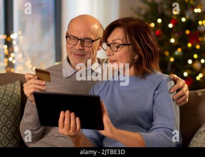 Ältere Paare, die Weihnachten online einkaufen Stockfoto