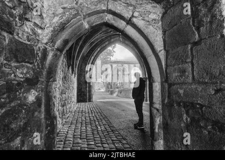 Tourist im Whalley Abbey Gatehouse mit Blick auf das Whalley Viadukt (entworfen in Übereinstimmung mit den Torhausbögen), Ribble Valley, Lancashire, Engl Stockfoto
