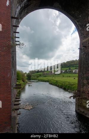 Whalley Viaduct - eine Eisenbahnbrücke mit 48 Spannweiten - Blick durch einen Bogen entlang des Flusses Ribble, Ribble Valley, Lancashire, England, Großbritannien Stockfoto