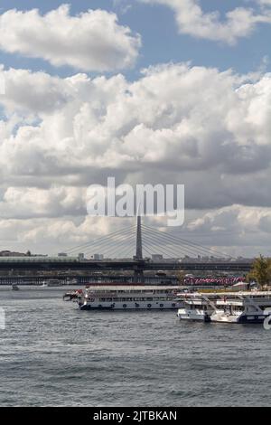 Blick auf geparkte Ausflugsboote am Goldenen Horn des Bosporus und der Halic-Brücke in Istanbul. Es ist ein sonniger Sommertag. Stockfoto