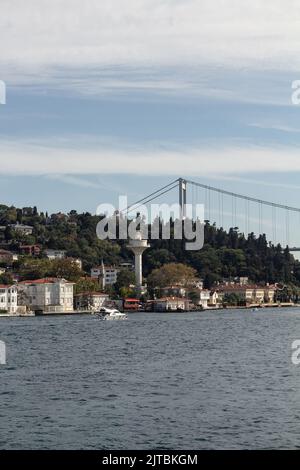 Blick auf eine Yacht, die am Kanlica-Viertel am Bosporus auf der asiatischen Seite Istanbuls vorbeifährt. Es ist ein sonniger Sommertag. Wunderschöne Reiseszene. Stockfoto