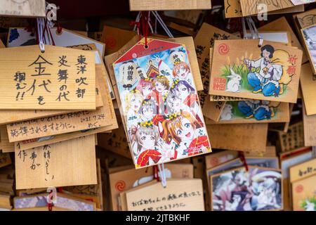 Japanische Anime- und Manga-Figuren, die auf ema-Gebetstafeln am Kanda Myojin-Schrein gemalt sind, einem schintoistischen Schrein, der Geschäftsreisenden und Technikbegeisterten in Chiyoda, Tokio, Japan, gewidmet ist. Die Gläubigen hängen die Tafeln mit ihren Wünschen, Träumen oder Gebeten im Tempel auf. Stockfoto