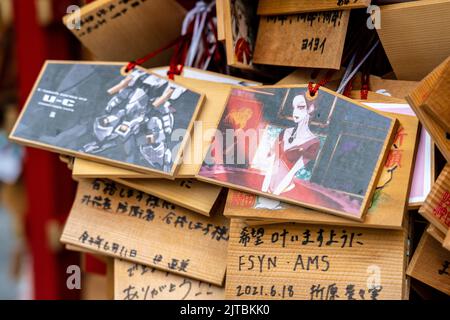 Japanische Anime- und Manga-Figuren, die auf ema-Gebetstafeln am Kanda Myojin-Schrein gemalt sind, einem schintoistischen Schrein, der Geschäftsreisenden und Technikbegeisterten in Chiyoda, Tokio, Japan, gewidmet ist. Die Gläubigen hängen die Tafeln mit ihren Wünschen, Träumen oder Gebeten im Tempel auf. Stockfoto