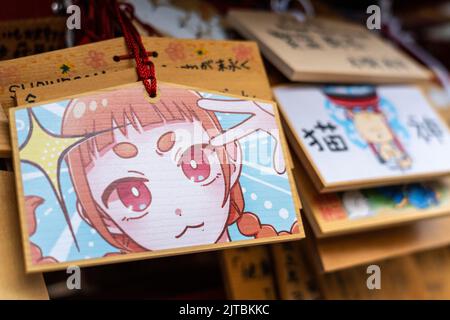 Japanische Anime- und Manga-Figuren, die auf ema-Gebetstafeln am Kanda Myojin-Schrein gemalt sind, einem schintoistischen Schrein, der Geschäftsreisenden und Technikbegeisterten in Chiyoda, Tokio, Japan, gewidmet ist. Die Gläubigen hängen die Tafeln mit ihren Wünschen, Träumen oder Gebeten im Tempel auf. Stockfoto