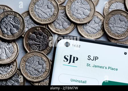 SJP-Anwendung auf dem Smartphone-Bildschirm auf britischen Pfund-Münzen platziert gesehen. St. James's Place (SJP) ist ein Beratungsunternehmen für Finanzexperten. Stafford, Einheit Stockfoto