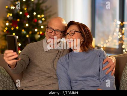 Altes Paar, das an weihnachten Selfie mit dem Telefon gemacht hat Stockfoto