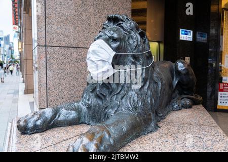 Die Bronzestatue der Mitsukoshi Ginza mit einer COVID-19 Gesichtsmaske am Haupteingang des Mitsukoshi Kaufhauses, Chuo-Ku, Tokio, Japan. Stockfoto