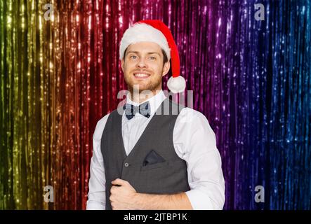 Glückliche Menschen in Santa Hut und Anzug auf Weihnachten Stockfoto