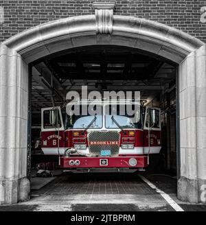 Ein Feuerwehrmotor, der in einer Station bereit sitzt Stockfoto