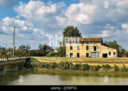 Italien, Lombardei. Altes verlassene Bauernhaus in der Po-Ebene, entlang eines Kanals. Stockfoto