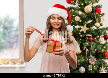 Teenager-Mädchen in santa Hut Eröffnung weihnachtsgeschenk Stockfoto