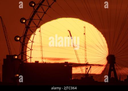 London, Großbritannien. 29.. August 2022. Wetter in Großbritannien: Dramatischer Sonnenuntergang hinter dem Riesenrad des London Eye, das einen warmen Montag an den Bankfeiertagen beendet. Kredit: Guy Corbishley/Alamy Live Nachrichten Stockfoto