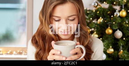 Frau trinkt heiße Schokolade zu Hause an weihnachten Stockfoto