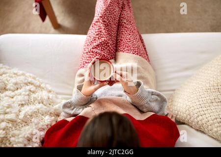 Frau, die zu weihnachten zu Hause Kaffee riechend Stockfoto