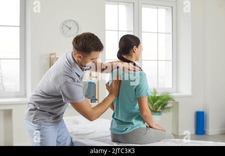 Chiropraktikerin, Osteopathin oder Physiotherapeutin, die mit einer jungen Frau mit Skoliose arbeitet Stockfoto
