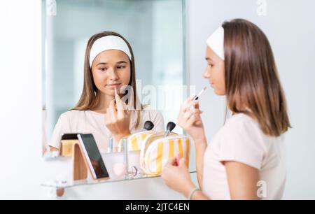 Teenager-Mädchen Anwendung Lipgloss im Badezimmer Stockfoto