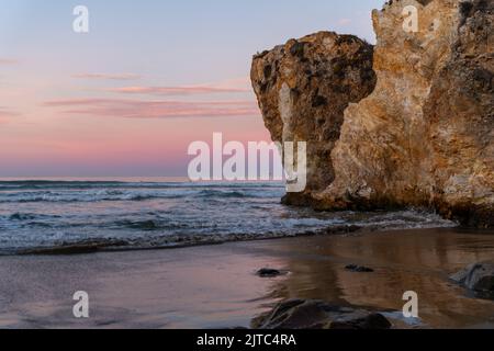 Eine malerische Aussicht auf den goldenen Sonnenuntergang über den Felsen im Meerwasser in Pismo Beach Stockfoto