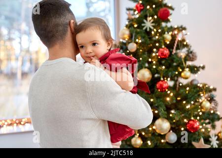 Glücklicher Vater und Mädchen über weihnachtsbaum Stockfoto