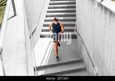 Junger Mann, der die Treppe rennt Stockfoto