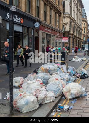 Überfließender Abfalleimer mit vielen vollen Plastiktüten auf dem Bürgersteig in der Gordon Street, im Zentrum von Glasgow, während eines Streiks von Müllsammlern des Rates. Stockfoto