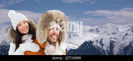 Glückliches Paar, das Spaß über Winter und Berge hat Stockfoto