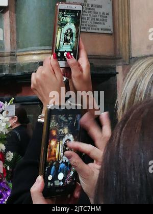 Eifrige Anhänger, die Fotos vom Hauptaltar und Prozessionsbild mit ihren Mobiltelefonen in der Kirche von Las Nazarenas machen - Herr der Wunder. Stockfoto