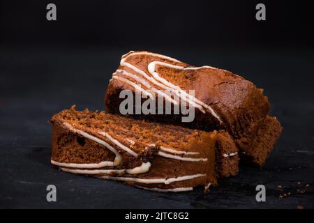 Hausgemachte Schokoladengebäck-Kuchenrolle in Scheiben auf schwarzem Hintergrund Stockfoto