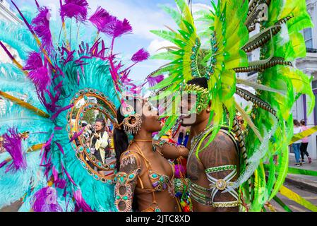 Schwarze weibliche und männliche Teilnehmer der Notting Hill Carnival Grand Parade am Montag, den 2022. August, an den Bankfeiertagen in London, Großbritannien. Exotische Kostüme Stockfoto