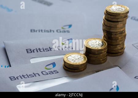 Stapel von 1-Pfund-Münzen auf den britischen Gasrechnungen in den Umschlägen. Konzept für Energiekrise und steigende Gaspreise in Großbritannien. Stafford, Großbritannien, Augus Stockfoto