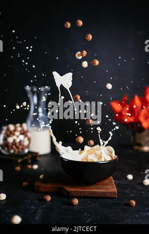 Magisches Frühstück mit fliegenden Cerealien und Milchspritzern Stockfoto