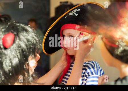 Der Animator zieht an halloween Spinnweben auf das Gesicht des Jungen Stockfoto