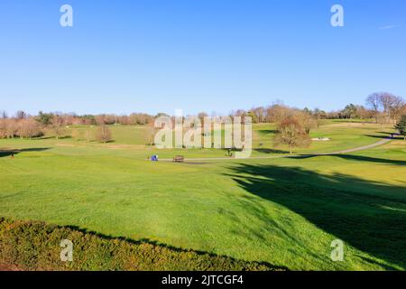 Blick auf Golfer, die an einem sonnigen Tag auf dem Golfplatz im privaten RAC-Mitgliederclub in Woodcote Park, Epsom, Surrey, Südostengland, spielen Stockfoto