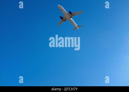 Low-Angle-Ansicht des kommerziellen Flugzeugs gegen den blauen Himmel Stockfoto