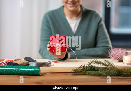 Nahaufnahme einer Frau, die zu Hause ein Weihnachtsgeschenk zeigt Stockfoto