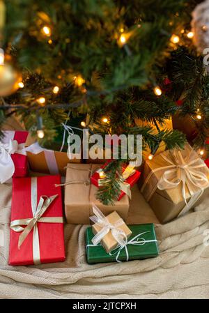Geschenke unter geschmücktem weihnachtsbaum zu Hause Stockfoto