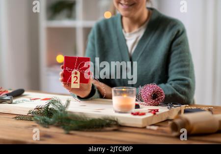 Nahaufnahme einer Frau, die zu Hause ein Weihnachtsgeschenk zeigt Stockfoto