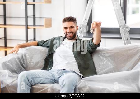 Mann mit Hausschlüsseln und Kisten zieht in ein neues Zuhause Stockfoto