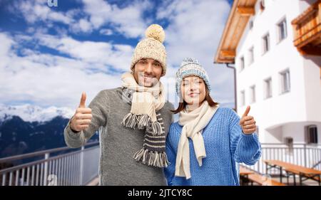 Glückliches Paar, das im Winter Daumen hoch zeigte Stockfoto