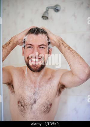 Seine tägliche Pflege Routine. Ein schöner junger Mann mit einer Dusche zu Hause. Stockfoto