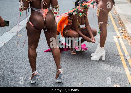 London, Großbritannien. 29. August 2022. Frauen am Notting Hill Carnival helfen sich gegenseitig mit ihren Kostümen. Hunderttausende von Feiernden haben die Rückkehr des Notting Hill Carnival nach einer dreijährigen Abwesenheit während der Pandemie gefeiert. Kredit: SOPA Images Limited/Alamy Live Nachrichten Stockfoto