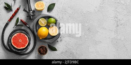 Teile von Shisha und Zitrusfrüchten auf hellem Hintergrund mit Platz für Text Stockfoto