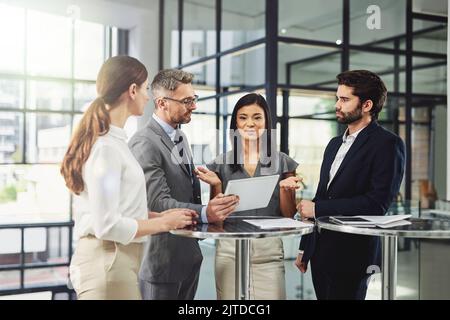 Alles beginnt mit einem Plan. Eine Gruppe von Kollegen diskutiert im Büro über das Geschäft. Stockfoto